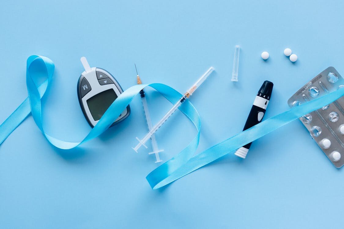 insulin, medication, and glucometer on a blue background