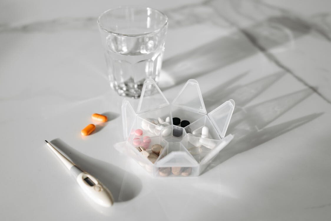 Advanced and digital thermometer with medicines on a wooden table